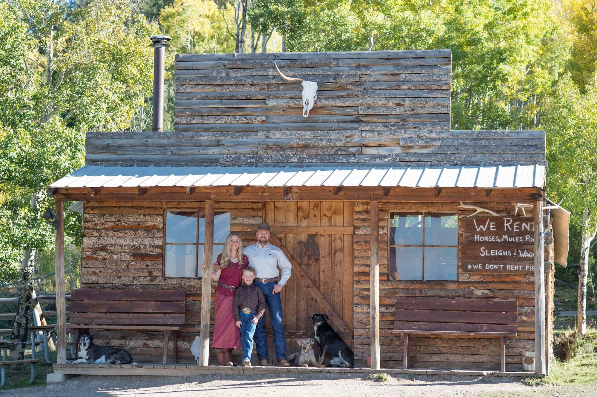 The Smith Family, Proud Owners of Rusty Spurr Ranch in Colorado in front of a cabin at the ranch.