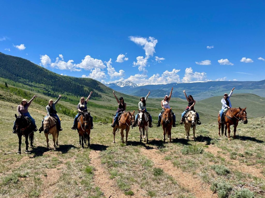group of women on a horseback trail ride in colorado