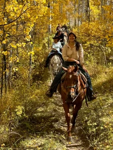Horseback riders enjoying colorful fall foliage on a September trail ride near Steamboat Springs.