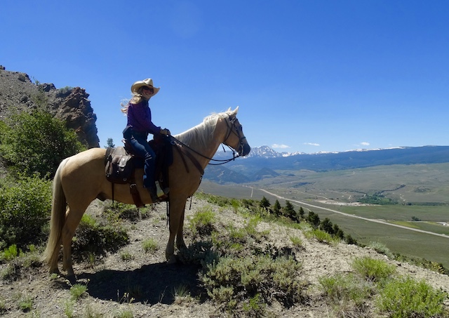 Close-up of a horse and rider navigating a rugged trail at Rusty Spurr Ranch, highlighting the intimate bond and adventure spirit.